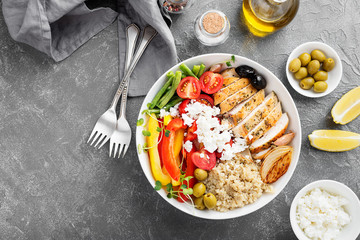 Lunch bowl with chicken, quinoa, feta cheese and fresh vegetables.