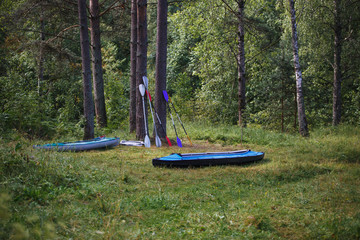 Two kayaks lie on the shore with oars. Preparing for water campaign, assembling kayak