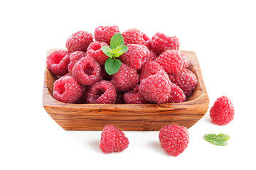 Fresh raspberry in a wooden plate isolated on white background.