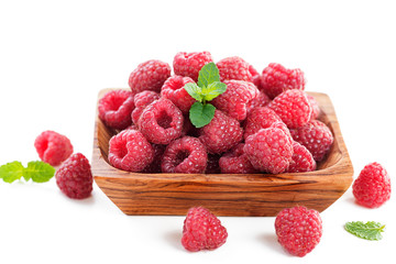 Fresh raspberry in a wooden plate isolated on white background.