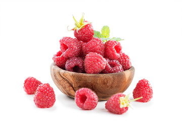 Fresh raspberry in a wooden plate isolated on white background.