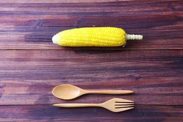 corn with wooden spoon and fork on brown wood table ,copy space.