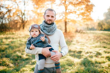 Naklejka na ściany i meble Happy father posing with his stylish child in autumn park