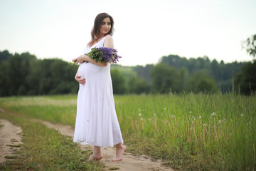 Fototapeta na wymiar Pregnant woman in nature for a walk in the summer