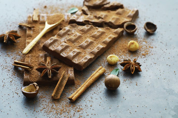 A bar of milk chocolate on the table. Chocolate with nuts and cinnamon.