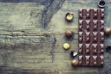 A bar of milk chocolate on the table. Chocolate with nuts and cinnamon.