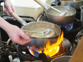 Cooking traditional Japanese ramen soup with miso paste, meat, noodles, seaweed and onion