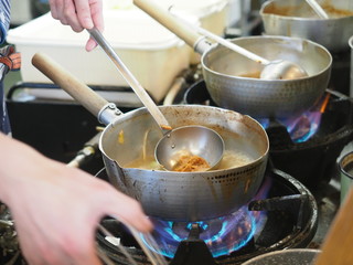 Cooking traditional Japanese ramen soup with miso paste, meat, noodles, seaweed and onion
