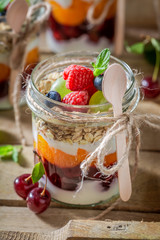 Homemade oat flakes with fresh berries and yoghurt in jar