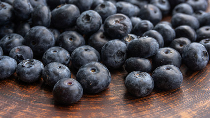 Blueberries and blueberries on the background of pottery. Black berries.