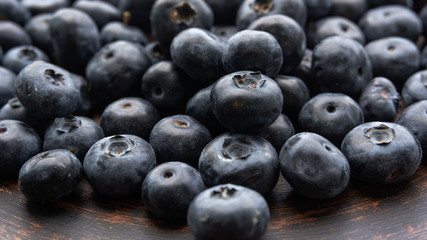 Blueberries and blueberries on the background of pottery. Black berries.