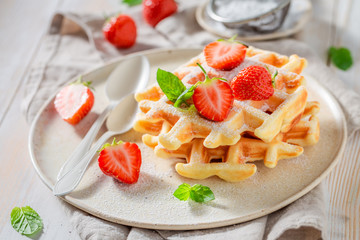 Homemade wafers with powdered sugar and sweet fruits