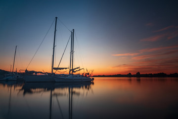 Fototapeta na wymiar Vacation holiday fishing journey sunrise Sail boat Yacht at quay. Nautical, relaxation.