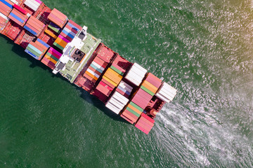 top aerial view of the large containers ship sailing in the sea carriage the shipment from loading port to destination discharging port, transport and logistics services to worldwide .