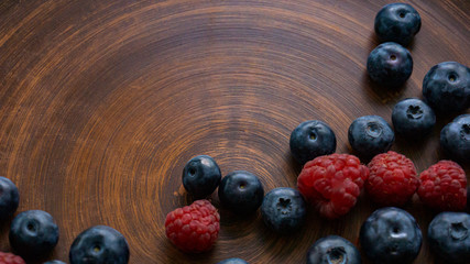 Blueberries and blueberries on the background of pottery. Black berries.