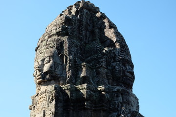 A huge human face built of stone blocks. Huge human faces on the towers of the Bayon temple in...