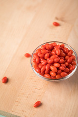 Frische Goji-Beeren Superfood in Glas Schale auf Holz Brett Hintergrund