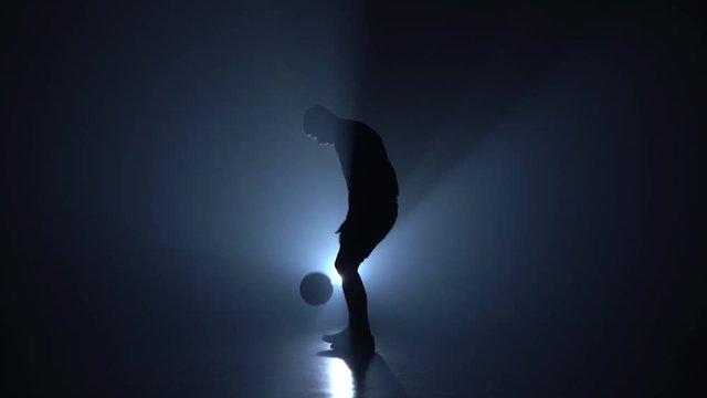 Professional soccer player is stuffing the ball on his feet.