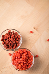 Frische und getrocknete Goji-Beeren Superfood in Glas Schale auf Holz Brett Hintergrund