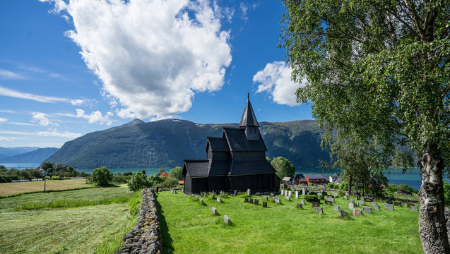 Urnes Stave Church, a 12th-century stave building at Ornes, along the Lustrafjorden in bright midsummer day. Built with a rectangular nave and a narrower choir. World Heritage Site by UNESCO. Norway.