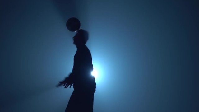 Close-up football freestyle at studio against spotlight
