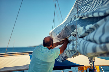 Sailor packing / unpacking main sail wing on the boat.