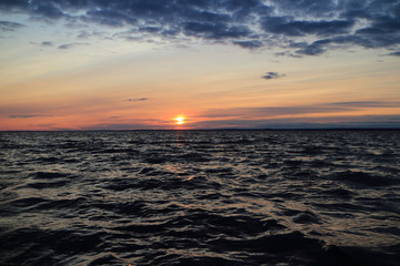 Obraz premium harsh sea in the evening at sunset, dramatic seascape setting sun red horizon