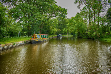 Narrowboats on a British canal in rural setting