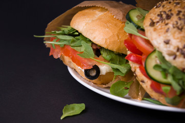 Veggie burger with tomatoes, mozzarella, arugula, paprika and olives