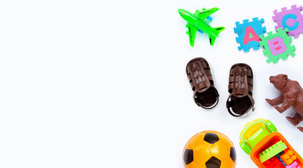 Brown leather children's sandals with colorful  toys on white background. Copy space