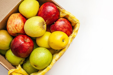 box with green, yellow and red apples isolated on white background