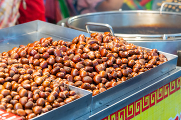 Roasted chestnuts on a tray at street food market.