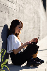 Young businesswoman working with her laptop computer sitting on the floor.