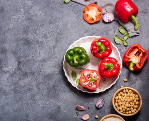 Stuffed vegetarian peppers or paprika with rice and chickpeas in round baking form bevor baking, vegan cooking, healthy summer lunch