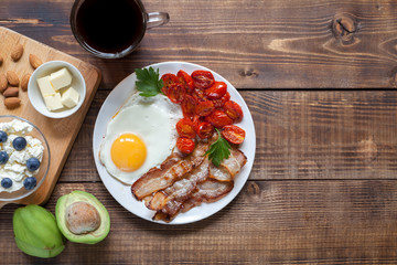 Keto breakfast: eggs, bacon, tomatos, avocado, butter, black coffee. Ketogenic diet. Healthy fats diet. 