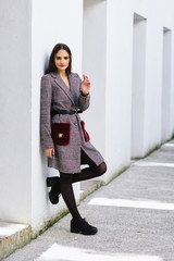 Obraz premium Beautiful girl with very long hair wearing winter coat and cap outdoors.