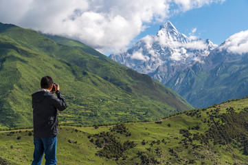 A photographer takes pictures for the Siguniang mountains in Sichuan, China.