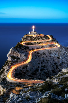 Cap Formentor lighthouse in blue hour evening light with car light streaks, mallorca, spain 