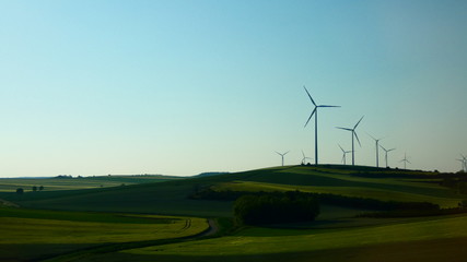 Wind turbines in green field with beauty blue sky in background