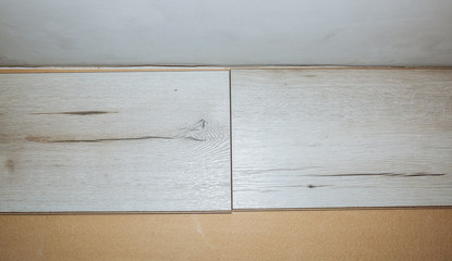 Laminate flooring in apartment. Maintenance repair works renovation. Restoration of wooden parquet planks indoors. Measure tape and pencil.