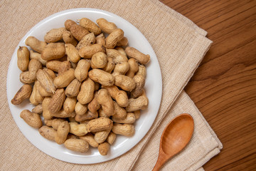 Roasted peanuts on the table, covered with brown fabric, suitable for advertising