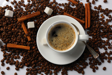 Cup of coffee, coffee beans, cinnamon and sugar