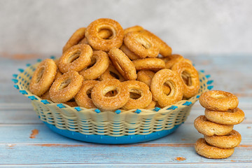 Small sweet bagels in a wicker bowl on light blue wooden background