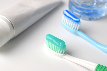 Toothbrush and toothpaste on white table in bathroom