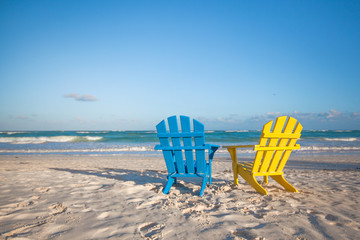 Beach wooden colorful chairs for vacations on tropical beach in Tulum