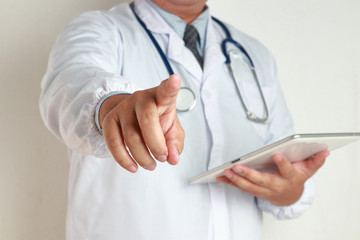 Male doctors wear a tie, hold a tablet, see treatment information, raise the right hand, index finger.
