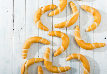 crescent rolls on white wooden table, directly above