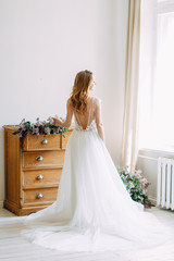 Fototapeta premium Wedding in European style. Stylish trendy bride in the Studio with a bouquet of lilacs.