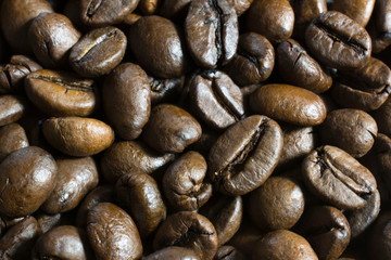 Background of roasted coffee beans scattered on the table.