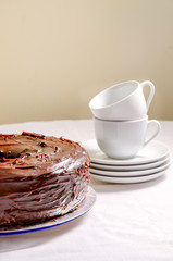 Freshly baked of homemade chiffon chocolate cake. Chocolate cake and white dishes on white background, close up.